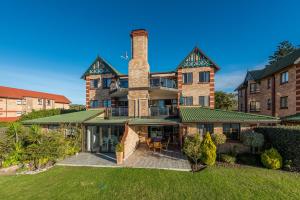 una vista exterior de una gran casa de ladrillo con chimenea en Beacon Wharf , George Hay 3 Holiday Accommodation, en Mossel Bay