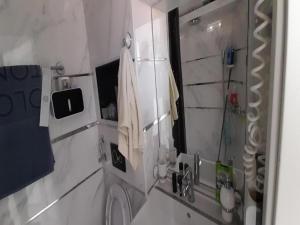 bagno con lavandino e doccia con specchio di Apartment OM a Povlja