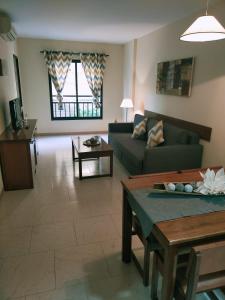 ein Wohnzimmer mit einem Sofa und einem Tisch in der Unterkunft PISO MACARENA RONDA 4 LOS BOLICHES in Fuengirola