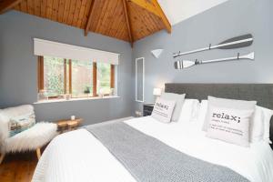 a bedroom with a bed with white sheets and a window at Curlew Cottage in Uny Lelant