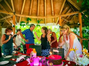 a group of people standing around a table with a cake at Sabba Beach Suite , Fodhdhoo - Maldives in Velidhoo