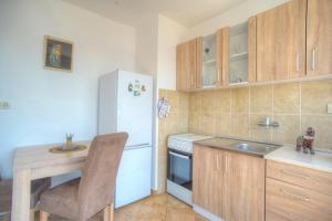 a kitchen with a white refrigerator and a table at Lala in Herceg-Novi