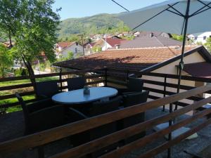 a table and chairs on a balcony with an umbrella at Studio Apartman Sun in Jajce