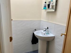 La salle de bains blanche est pourvue d'un lavabo et de toilettes. dans l'établissement Arnside sea view, à Arnside