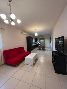 a living room with a red couch and a tv at ZMARIAS in Perakhórion