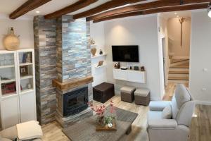 a living room with a fireplace and a tv at Casa de los abuelos 6 personas in Olvera