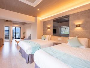 廿日市的住宿－LiVEMAX RESORT Miyahama Ocean View，酒店客房设有三张床和电视。