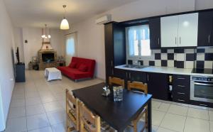 a kitchen and living room with a table and a red couch at ZMARIAS in Perakhórion