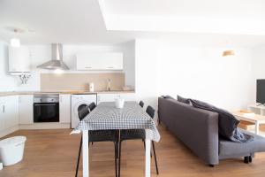 eine Küche mit einem Tisch und Stühlen im Zimmer in der Unterkunft Global Properties, Moderno apartamento con terraza y vistas al mar in Canet d'en Berenguer
