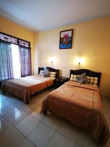 a bedroom with two beds and a window at Celebbest in Kuta