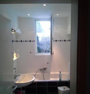 łazienka z wanną, umywalką i oknem w obiekcie 6 schöne CITY- Zimmer w Hanowerze
