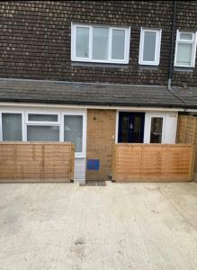 a house with wooden garage doors at Basingstoke 1x Double bed and Sofa bed in Sherborne Saint John