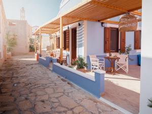 a house with a patio with a table and chairs at Captain's Memories Stylish Harbour Apartments in Halki