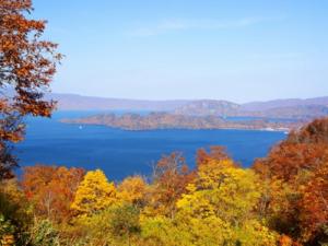a view of a lake in the fall at Hotel Towadaso in Towada