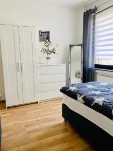 a bedroom with a bed and a dresser and a mirror at KriDa Apartment in Garbsen