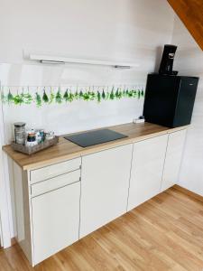 ガルプセンにあるKriDa Apartmentの白いキャビネットと緑のガーランドのあるキッチン