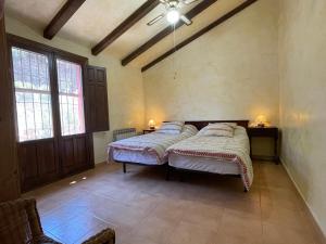 two beds in a room with two windows at Casa Ramoncico. Finca el Campillo in Blanca