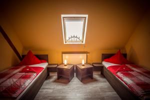 2 camas en una habitación con ventana y 2 velas en Ferienhof Kürschner en Drebach