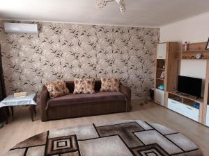 sala de estar con sofá y pared en Casa Body_Adda en Corbu