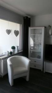 - un salon avec une chaise blanche et une fenêtre dans l'établissement Fewo 8 Steffens, à Goslar
