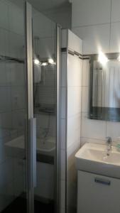La salle de bains est pourvue d'un lavabo et d'une douche en verre. dans l'établissement Fewo 8 Steffens, à Goslar