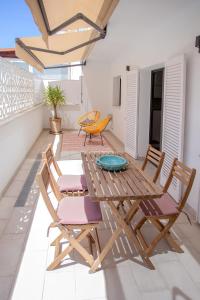 a patio with a wooden table and chairs at Destino Sitges in Sitges