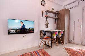 sala de estar con TV colgada en la pared en Kataleya Studio, en Mamaia Nord – Năvodari