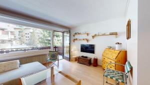 uma sala de estar com um sofá e uma grande janela em Guardaval 13 em Surlej