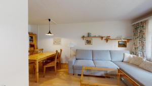 uma sala de estar com um sofá azul e uma mesa em Guardaval 13 em Surlej