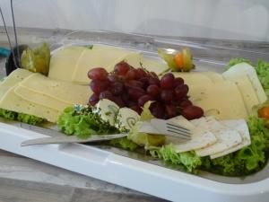 a plate of food with cheese and grapes at Pension Haus Baltic in Dahme