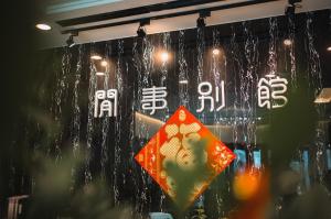 een venster van een winkel met een Chinees bord bij Xien Shi Homestay in Jinning