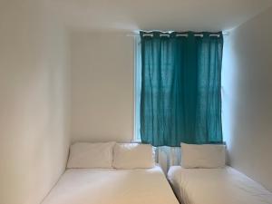 a bedroom with two beds and a window at Brick lane stay in London