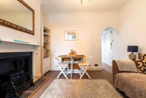 a living room with a fireplace and a table and chairs at Shelley’s Seaside Stay (Garden/ Double Drive) in Porthcawl