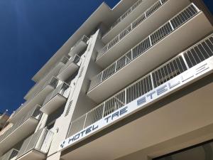 a white building with a sign on the side of it at Hotel Tre Stelle Gabicce Mare in Gabicce Mare