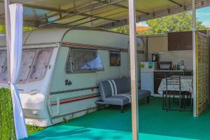 ein weißer Wohnwagen mit einem Tisch und einer Küche in der Unterkunft Sunny House Caravans in Sozopol