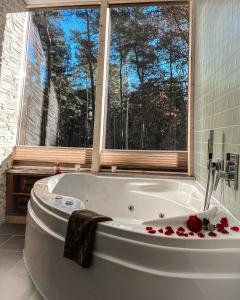 ein Badezimmer mit einer Badewanne mit Rosen in der Unterkunft Tree Inn - Das Baumhaushotel in Dörverden