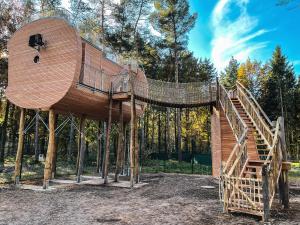drewniany domek na drzewie ze schodami w lesie w obiekcie Tree Inn - Das Baumhaushotel w mieście Dörverden