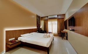 um quarto com uma cama, uma secretária e uma televisão em Hotel Fortune em Rameswaram