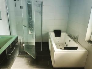 La salle de bains est pourvue d'une douche, d'une baignoire et d'un lavabo. dans l'établissement gehobene Ferienwohnung im schönen Odenwald, à Fürth