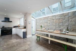 a large kitchen with a stone wall at Elysian in St Ives