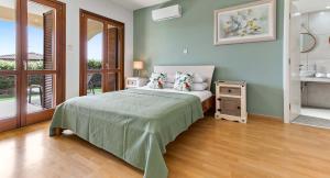 a bedroom with a bed with pillows and a table at Apartment KZ01 - Modern ground floor apartment in the heart of Aphrodite Hills Resort in Kouklia +35 photos