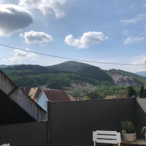 a white chair on a balcony with a view of a mountain at L Atypik à L ancienne forge in Muhlbach-sur-Munster