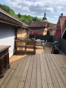 a wooden deck with a table on a roof at L Atypik à L ancienne forge in Muhlbach-sur-Munster