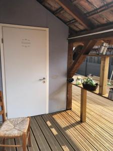 a white door with a sign on it on a deck at L Atypik à L ancienne forge in Muhlbach-sur-Munster