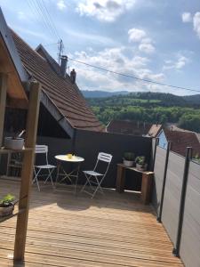 a balcony with chairs and a table on a roof at L Atypik à L ancienne forge in Muhlbach-sur-Munster