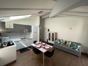 a kitchen and living room with a table and a couch at Appartamento Le 3 Cime in Trento