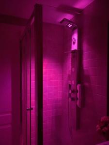 een paarse badkamer met een douche met roze verlichting bij LATA LUXURY HOME CASA VACANZE in Brindisi