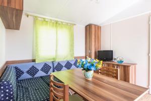 una sala de estar con una mesa de madera con flores. en House&Villas - Residence Il Borgo, en Avola