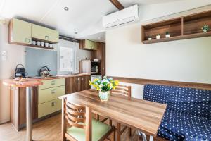 cocina y comedor con mesa de madera y sillas en House&Villas - Residence Il Borgo, en Avola