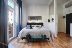 ein Schlafzimmer mit einem Bett mit einem grünen Stuhl in der Unterkunft E&F Luxury Apartments in Pula